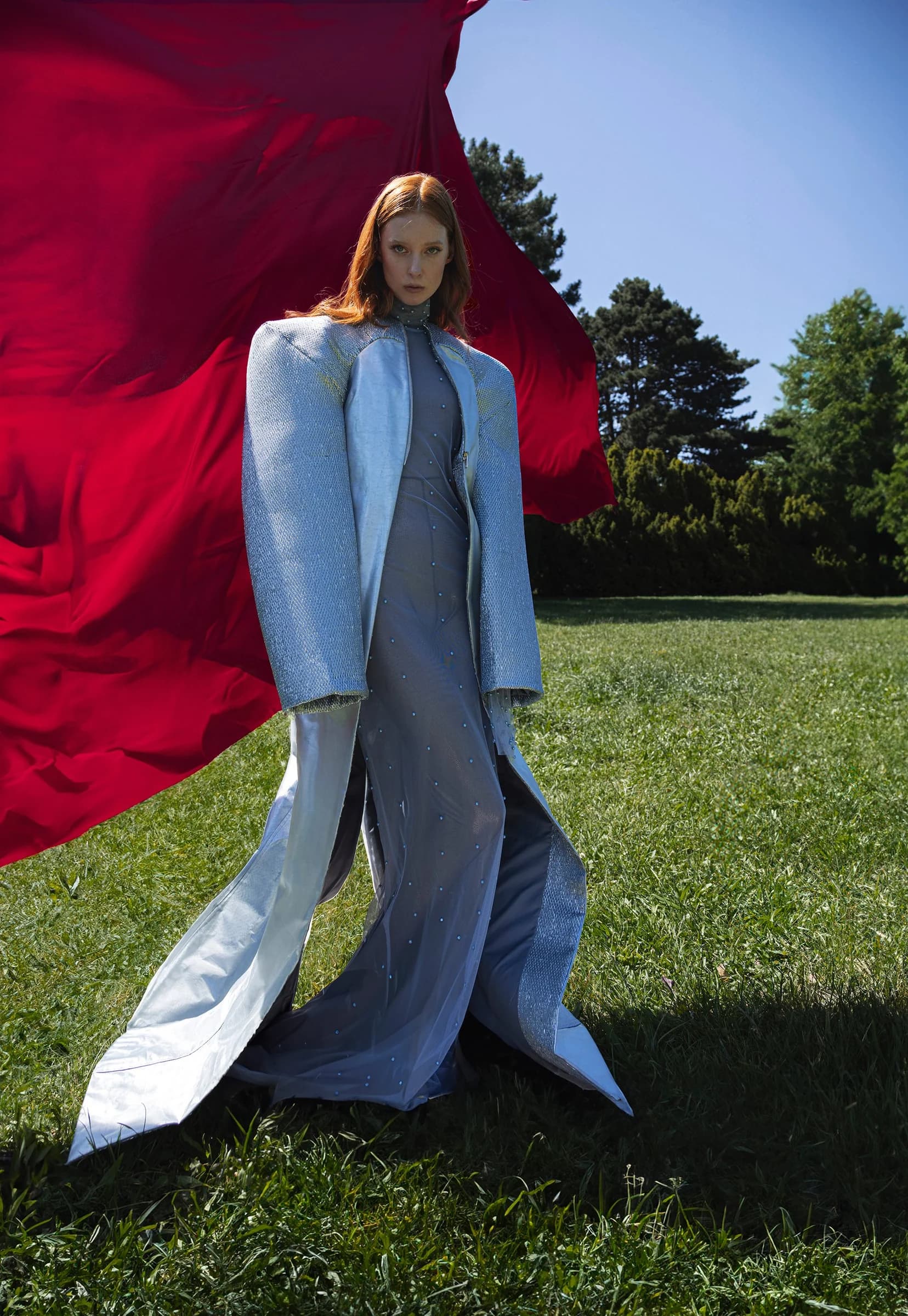 Model in Hellblau vor rotem Stoff unter freiem Himmel – Laura