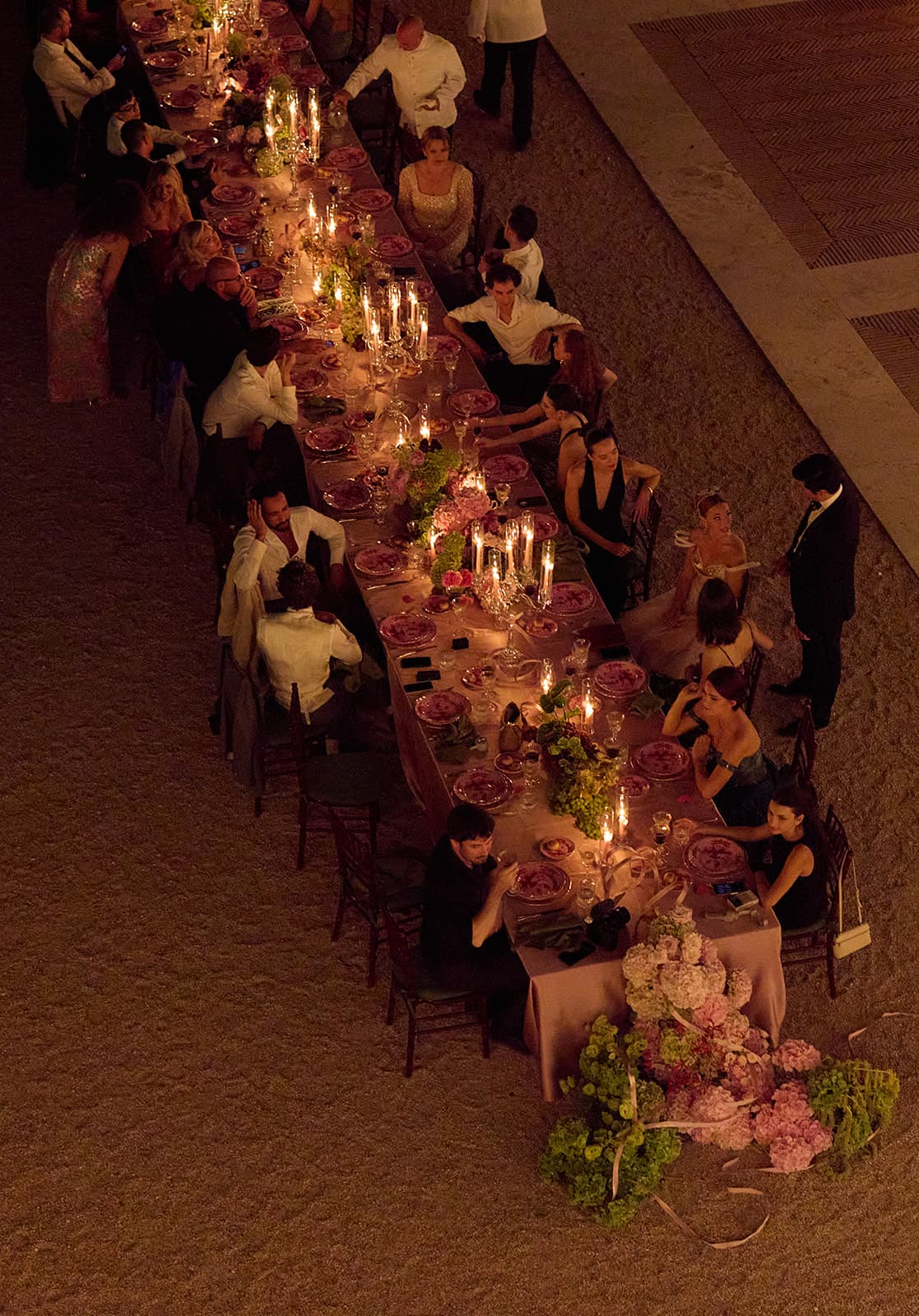 Die Gäste an der beleuchteten Hochzeitstafel bei Nacht